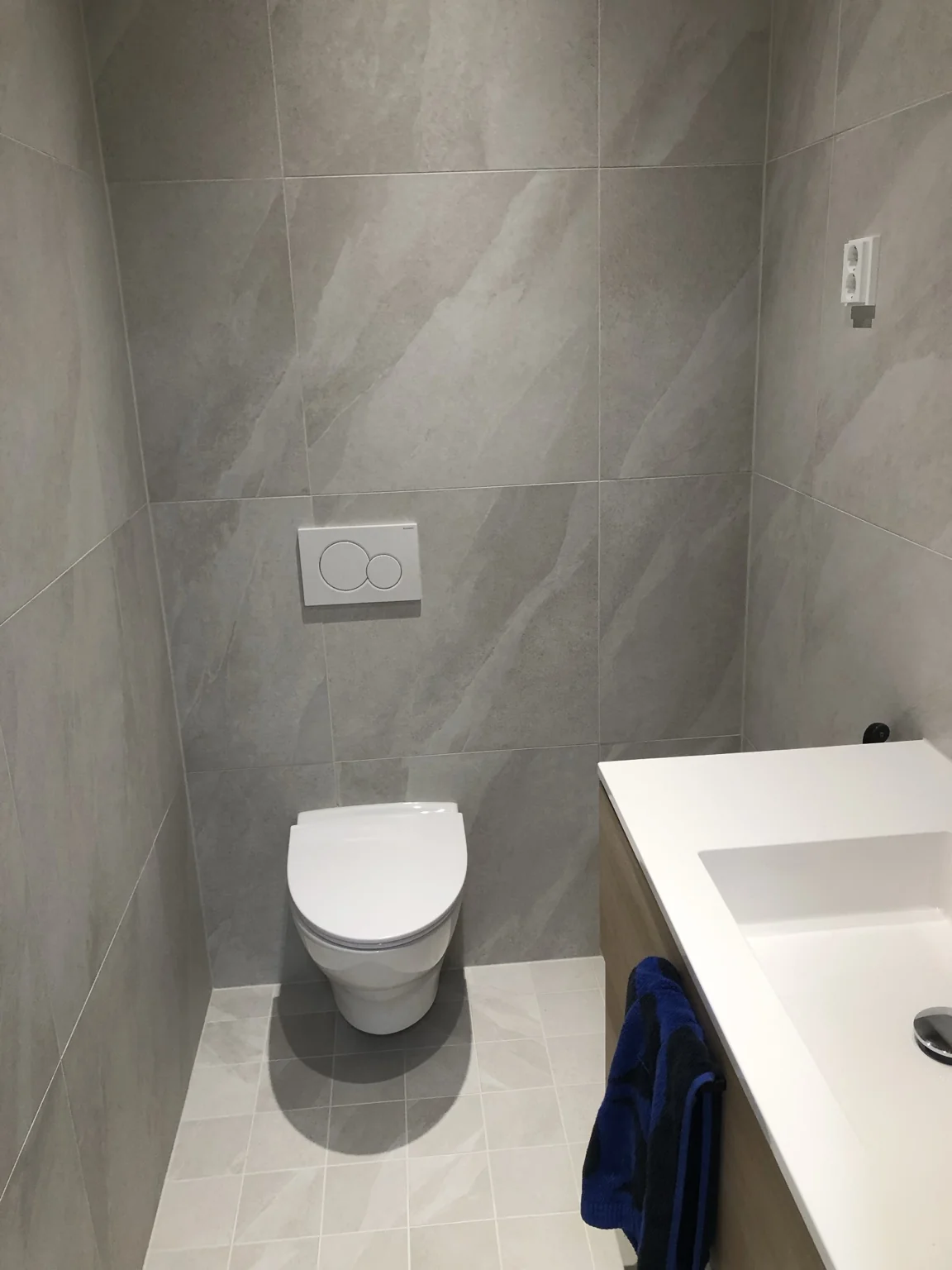 Uudistettu WC, harmaat pinnat ja valkoinen kalustus