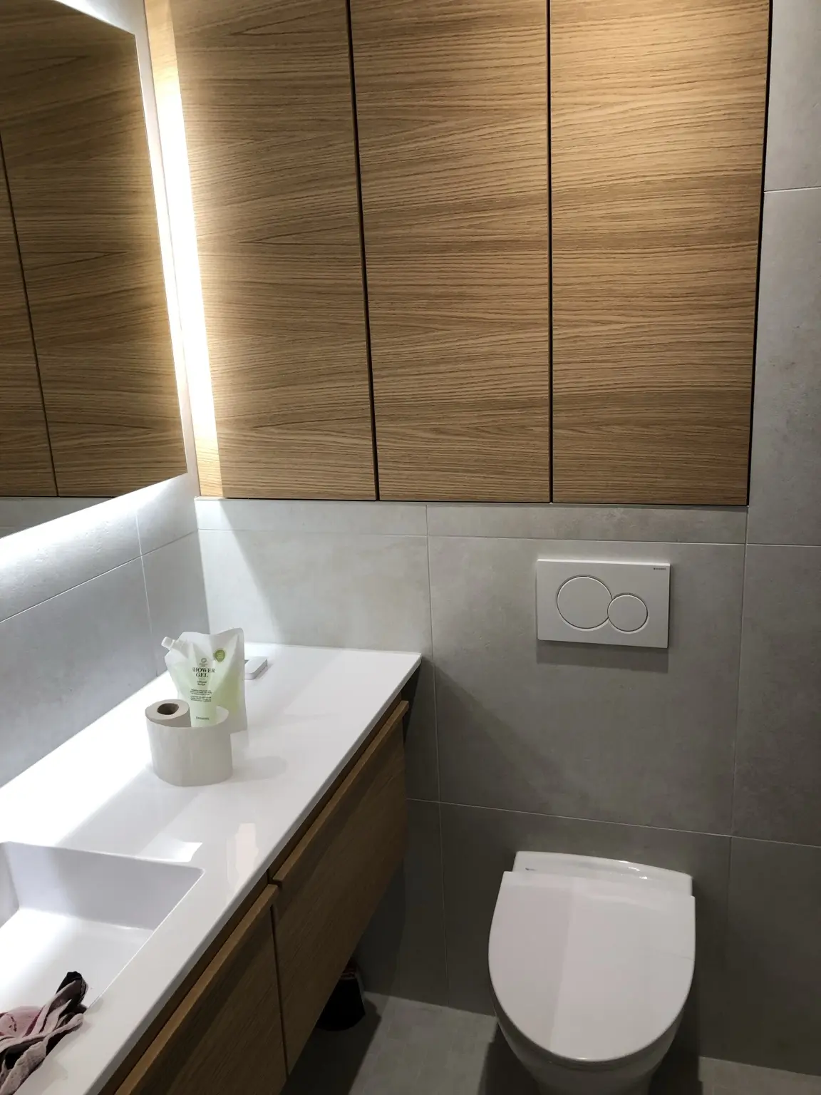 Moderni WC-tila, puukalusteet ja epäsuora valaistus